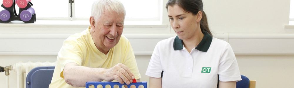 Liverpool OT plays a game of connect four with happy client during therapy.
